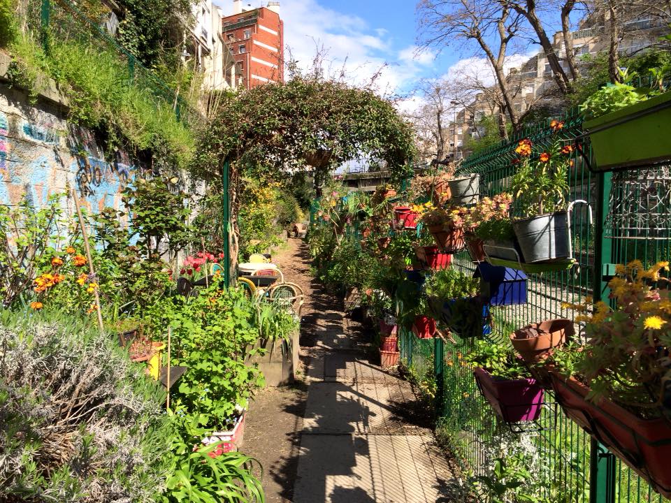 Les Jardins du Ruisseau is distinguished by its innovative use of repurposed railway tracks as raised garden beds